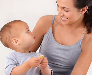 Image showing Bonding, bed and mother with baby eating biscuit for yummy, delicious and nutrition snack. Child development, love and young mom with boy kid, infant or toddler enjoying a cracker in bedroom at home.