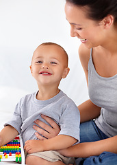 Image showing Mom playing with happy toddler in home with toys, bonding and child care with abacus in morning on bed. Woman, playful baby boy and fun together in bedroom with development, smile and mothers love.