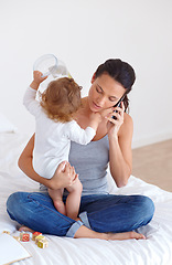 Image showing Phone call, playing and mother with baby on bed for communication and bonding together at modern house. Discussion, fun and young mom on mobile conversation and holding toddler in bedroom at home.