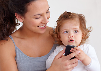 Image showing Phone, playing and mother with toddler on bed for bonding and watching video on social media together. Happy, love and young mom scroll on cellphone with girl child, kid or baby in bedroom at home.