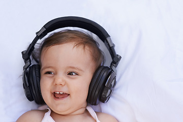 Image showing Baby, headphones and listening to song for fun, above and face on bed at home. Child, happiness and hearing audio for child development or learning, toddler and calming playlist for peace and calm