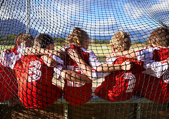 Image showing Team, soccer player and ball on goal net, back and embrace for game, field and child. Outdoor, playful and sport for childhood, portrait and athlete for match, alone and outside on football pitch