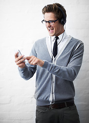 Image showing Man, headphones and listening to music and phone for rock song by wall background, singing and sound. Male person, smartphone and streaming radio or podcast, playlist and hearing audio and mobile app