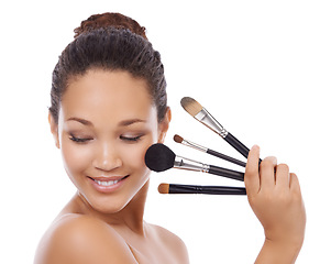 Image showing Woman, beauty and makeup brushes on face for cosmetics, skincare or blush against a white studio background. Female person or model smile for facial treatment, foundation or textures on mockup space