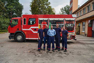 Image showing A skilled and dedicated professional firefighting team proudly poses in front of their state of the art firetruck, showcasing their modern equipment and commitment to ensuring public safety.