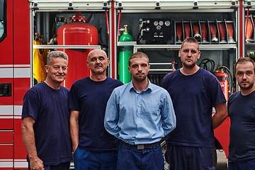 Image showing A skilled and dedicated professional firefighting team proudly poses in front of their state of the art firetruck, showcasing their modern equipment and commitment to ensuring public safety.