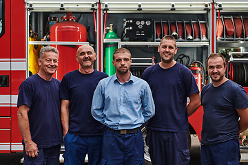 Image showing A skilled and dedicated professional firefighting team proudly poses in front of their state of the art firetruck, showcasing their modern equipment and commitment to ensuring public safety.