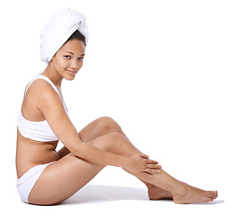 Image showing Happy woman, legs and skincare in studio portrait for hair removal results and beauty on floor on a white background. Young person or model in underwear with body cosmetics, dermatology and hygiene