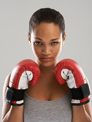 Image showing Serious woman, portrait and professional boxer ready for fight or competition against a gray studio background. Female person with boxing gloves for self defense, power or challenge in sports fitness