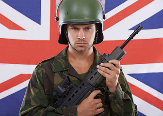 Image showing Military, Britain and gun with portrait of man in studio for war, conflict and patriotic. Army, surveillance and security with person and rifle on uk flag for soldier, battlefield or veteran training