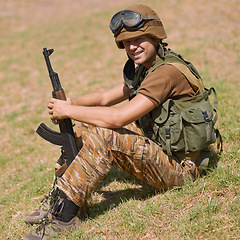 Image showing Military, smile and training with man and gun in nature for war, conflict and patriotism. Army, surveillance and security rifle with person and relax on grass for soldier, battlefield and veteran