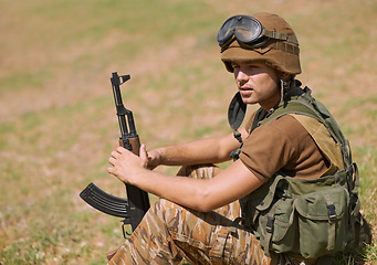 Image showing Military, thinking and man with gun in nature for war, conflict and patriotism. Army warrior, surveillance and security with person relax on grass in outdoors for soldier, battlefield and veteran