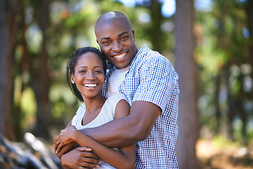 Image showing Hug, portrait or black couple hiking in forest to relax or bond on holiday vacation together in nature. Happy, travel or African woman with smile or man in woods trekking on outdoor park adventure