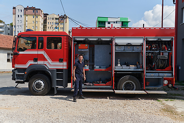 Image showing A dedicated firefighter preparing a modern firetruck for deployment to hazardous fire-stricken areas, demonstrating readiness and commitment to emergency response