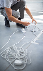 Image showing Hands, man and electrician plug connection, power and electricity in office. Cord, wire and cable on floor, socket and energy of worker, professional or employee charging on technology in workplace