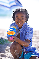 Image showing Child, water gun and beach to play, portrait and happy with sand, fighting and swimwear for summer vacation. Nature, resting and enjoy for holiday, sun tan or seaside in outdoor, beautiful or ocean