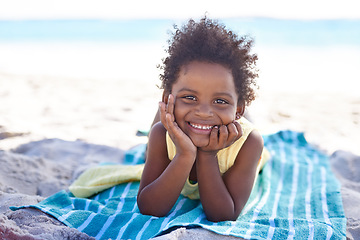 Image showing Smile, african child and portrait on beach sand, towel and summer holiday with sunshine in nature. Black girl, young and happy face to relax on vacation, cape town and ocean for wellness in outdoor