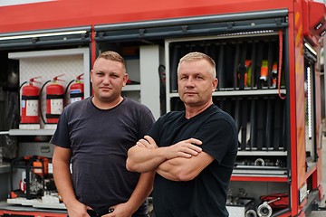 Image showing A skilled and dedicated professional firefighting team proudly poses in front of their state of the art firetruck, showcasing their modern equipment and commitment to ensuring public safety.