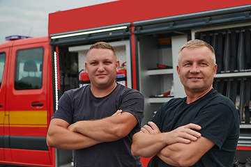 Image showing A skilled and dedicated professional firefighting team proudly poses in front of their state of the art firetruck, showcasing their modern equipment and commitment to ensuring public safety.