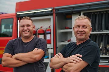 Image showing A skilled and dedicated professional firefighting team proudly poses in front of their state of the art firetruck, showcasing their modern equipment and commitment to ensuring public safety.