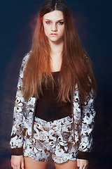Image showing Portrait, fashion and a serious young woman in studio on a dark background for clothing style. Hair, flare and intense with a confident redhead model in a trendy, casual or relaxed clothes outfit