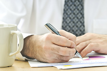 Image showing Office worker writing on reports