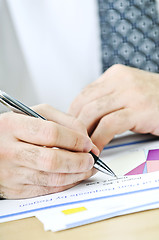 Image showing Office worker writing on reports