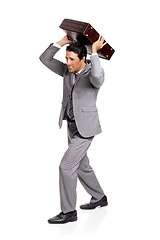 Image showing Angry, stress and business man with briefcase throw in studio frustrated on white background. Burnout, pressure and male entrepreneur with crisis, disaster or overwhelmed by deadline, mistake or fail