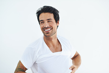 Image showing Thinking, smile and a young man dressing in studio isolated on white background at the start of his morning. Idea, vision and getting ready with a happy person in a tshirt or casual clothing outfit