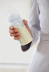 Image showing Business, woman and baby bottle with mom in suit, working and balance a career with motherhood. Hand, closeup and mother with milk in container for child, care and management of family with a job