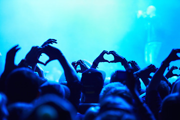 Image showing People, heart hands and crowd with blue light for music concert for love, support and care of artist. Audience, fans and nightlife together with gesture for unity, community or solidarity at festival