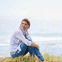 Image showing Woman, thinking and relax at beach in nature with happiness, gratitude and peace on holiday or vacation. Mindfulness, mock up and person on hill at the ocean or sea with ideas for future or travel
