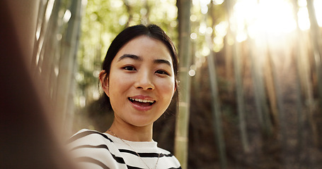 Image showing Japanese woman, selfie and bamboo forest for portrait with smile, pride and bush for post on web blog. Girl, person and happy influencer on adventure, trekking and hiking by trees for social network
