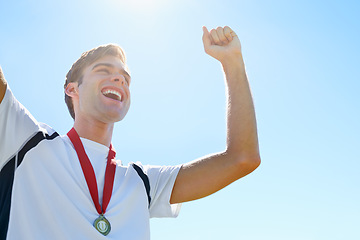 Image showing Winner, man or athlete with sports medal for achievement, success and celebration in running competition. Happy or excited runner with fist, power and wow for gold award. prize or goals on a blue sky