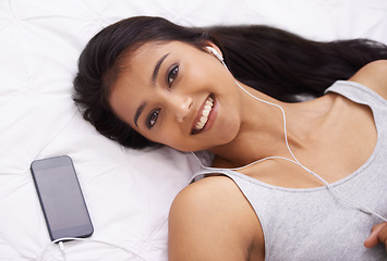 Image showing Woman, relax on bed and phone for music with smile for podcast, audio and streaming at home. Portrait of a young person on a break with mobile app and screen for listening to happy song in bedroom