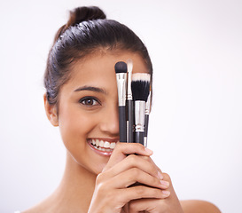 Image showing Makeup, brushes and woman face with eyes cosmetics in studio for beauty and foundation on a white background. Young model, artist or person in portrait for skincare, eyeshadow or product for coverage