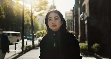 Image showing Walking, trees and Japanese woman in the city for tourist sightseeing in the street on weekend trip. Serious, adventure and young female person commuting in road of urban town in Kyoto Japan.