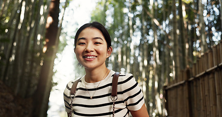 Image showing Japanese woman, portrait and bamboo in forest with smile, pride and backpack for travel on holiday in bush. Girl, person and happy with hiking by plants, freedom and outdoor by trees, woods or nature