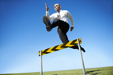 Image showing Businessman, hurdle and jumping for career obstacle or competition or employee challenge, growth or achievement. Male person, leap and work professional goals for overcome, job development or mockup