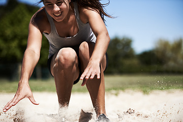 Image showing Woman, sand and long jump athlete outdoor training for endurance competition, skill or performance. Female person, face and fitness goal for cardio achievement practice or leap run, wellness or sport