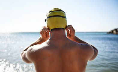 Image showing Sports, ocean and back of man for swimming exercise, workout or training in beach, nature or water. Back, swimwear cap and athlete ready to start challenge, fitness contest or practice for triathlon