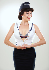 Image showing Travel, flight attendant and portrait of happy woman in studio isolated on a white background in Spain. Fashion, air hostess and smile of retro sailor person, pin up girl or stewardess model in hat