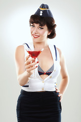 Image showing Portrait, stewardess and happy woman with alcohol to drink in studio isolated on white background. Face, martini cocktail glass and air hostess with service, travel and vintage pin up girl on journey