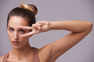 Image showing Portrait, beauty and peace sign with natural woman in studio on gray background for wellness or confidence. Face, skincare or hand gesture and serious young model with v fingers for cosmetics