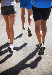 Image showing People, fitness and legs running for workout, fitness or outdoor exercise together on asphalt or road. Closeup of athletic group or runners in sports training, teamwork or cardio on urban street