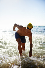 Image showing Sports, sea waves and man for swimming exercise, workout or training routine in beach, nature or ocean. Mockup space, sky and person ready for cardio, fitness or triathlon practice in water splash