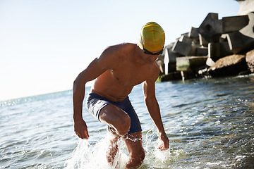 Image showing Beach sports, fitness and man for swimming training, workout or exercise in sea, nature and island. Active hobby, water splash and wet swimmer for cardio, challenge or practice in outdoor Greece