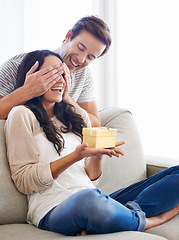 Image showing Surprise, cover eyes or couple with present in home for love or playful in marriage with anniversary in lounge. Man, hands or woman for gift in relationship, care together or celebrate in apartment