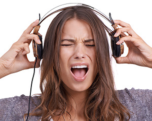 Image showing Woman in studio with headphones, noise and scream in pain with feedback, sound or audio. Face of angry girl listening to music, podcast or streaming service online with technology on white background