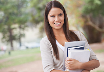 Image showing Student, portrait and books with smile in outdoor nature, technology and education in learning for studying. University, young woman and face for phd research, park and commitment for scholarship